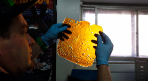 A man holds a sheet of THC concentrate known as "shatter," in Denver, Colorado. (Brennan Linsley/Associated Press)